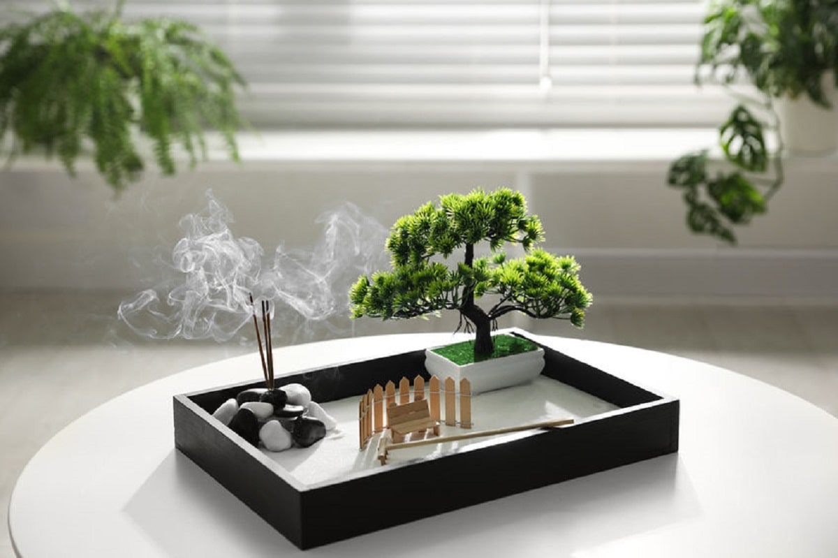 giardino zen da tavolo con incenso, sabbia e bonsai