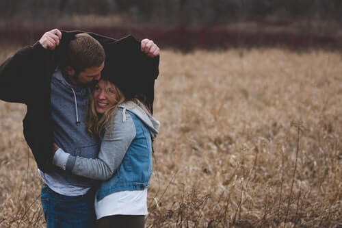 giovane-coppia-felice-in-un-campo-di-grano-proteggere-pioggia-intimità-nella-coppia