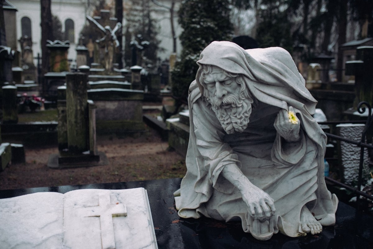 statua di un uomo all'interno di un cimitero